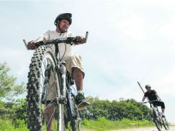 Paseantes con el reglamentario casco, en la entrada al área verde. EL INFORMADOR /