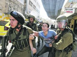 Un manifestante palestino es detenido por la Policía israelí durante los disturbios que se desataron en la ciudad de Hebrón. EFE /