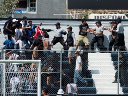 La barra de Querétaro ingresó a la fuerza al estadio y fue sacada a golpes por la policía local. MEXSPORT /