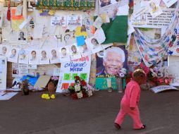 Un niño pasa junto a un muro con mensajes de apoyo a Nelson Mandela, afuera del hospital en el que esta internado. AP /