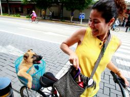 Una joven pasea en su bicicleta acompañada por su mascota. ARCHIVO /