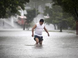 Un hombre camina entre la lluvia e inundaciones provocadas por las tormentas tropicales en Veracruz. AP /