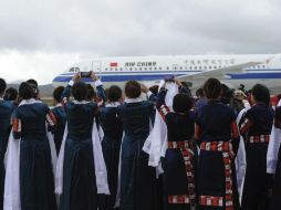 Un grupo de mujeres tibetanas tomando fotografías del vuelo CA 4215 de Air China.  /