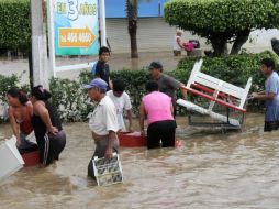 Un grupo de personas carga productos saqueados de tiendas. EFE /