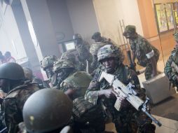 La policía irrumpe en el centro comercial para buscar a los atacantes. AP /