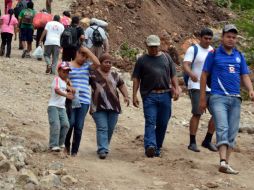 Un grupo de damnificados caminan un largo tramo entre sus comunidades y Chilpancingo para comprar víveres. NTX /