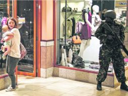 Una mujer protege a su bebé tras el tiroteo en el centro comercial Westgate, mientras un soldado monta guardia en el interior del lugar EFE /
