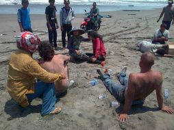 Turistas ayudan a los sobrevivientes del naufragio en las costas de Java. AP /