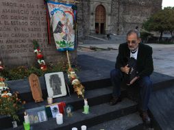 Enrique Espinoza, sobreviviente de la matanza, junto a un altar que recuerda a las víctimas. AP /