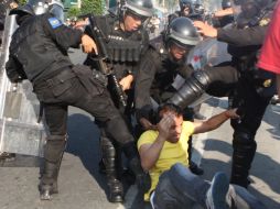 Jóvenes encapuchados se enfrentan a policías en el transcurso de la marcha. SUN /