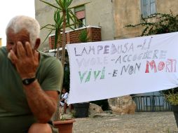 Un habitante de la localidad despliega una manta que dice ''Lampedusa quiere recibirlos vivos, no muertos''. AFP /