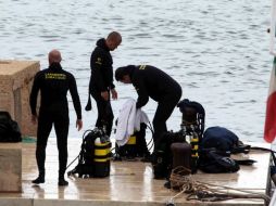 Varios buzos de un equipo de rescate permanecen en el puerto de la isla de Lampedusa. EFE /
