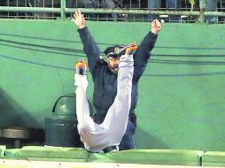 El policía que resguardaba el bullpen de los Medias Roja celebra el Grand Slam de Boston, mientras Torii Hunter cae de cabeza. AFP /
