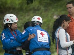 Miembros de la Cruz Roja colombiana consuelan a algunos familiares de las víctimas del derrumbe de una mina de oro. AFP /