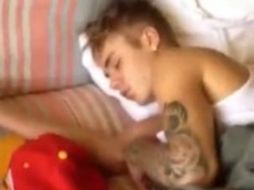 En la grabación, se observa a una mujer y al fondo, dormido en un sofá, se ve a Bieber. ESPECIAL /