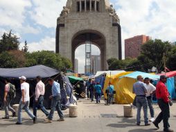 Trabajadores del GDF realizan labores de limpieza en el Monumento a la Revolución tras el repliegue del plantón. ARCHIVO /