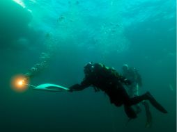 Tres submarinistas, cada uno de ellos con una antorcha olímpica, se pasaron  la llama bajo el agua a una profundidad de 13 metros. AFP /