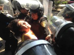 Una joven al momento de ser detenida por granaderos, afuera de Televisa. SUN /