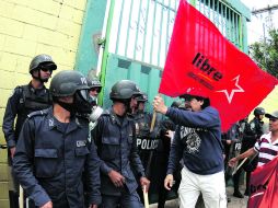 Alrededor de 100 policías antimotines custodiaron los portones del TSE; la movilización terminó sin incidentes. AP /