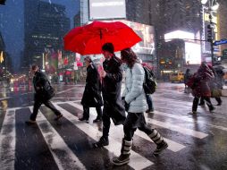 Peatones cruzan una calle de Manhattan durante una tormenta de nieve. AP /