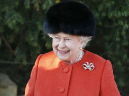 Con un abrigo naranja y un gorro de piel negra, la reina llegó a la ceremonia religiosa en la iglesia St. Mary. AP /