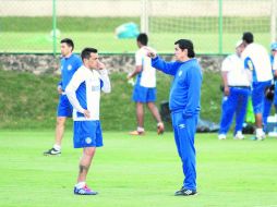 Christian Giménez escucha atento las indicaciones de Luis Fernando Tena durante el entrenamiento de ayer en La Noria. NTX /