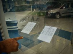 Un cubano apunta la lista de precios de carros nuevos y usados en la Habana. La venta fue autorizada oficialmente este viernes. ARCHIVO /