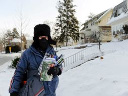 El empleado postal Chris Newbergen hace su labor enfrentándose a una temperatura de -25 grados centígrados, en Minneapolis. EFE /