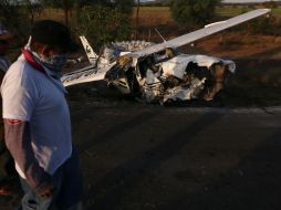 Miembros de un grupo de autodefensas observan la avioneta accidentada en la que viajaba su líder, Juan Manuel Mireles. EFE /