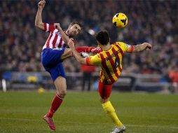 El capitán del Atlético, Gabi disputa un balón con Cesc Fabregas (de espaldas). AFP /