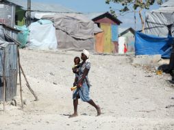 Una mujer caminando con un bebé en brazos por el campamento de desplazados en Carradeux, Puerto Príncipe. EFE /