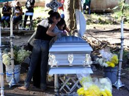 Familiares y amigos lloran al lado del ataúd de Rodrigo Benitez, quien murió durante los enfrentamientos. AFP /