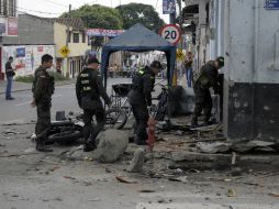Oficiales de la policía colombiana inspeccionan el lugar donde estalló la motocicleta. AFP /