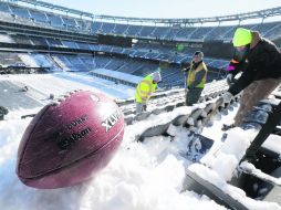 A marchas forzadas. Trabajadores del Estadio MetLife remueven la nieve de las gradas. AP /