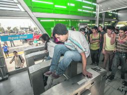 Varios inconformes por la tarifa brincan los torniquetes de ingreso a la estación Agua Azul del Macrobús.  /