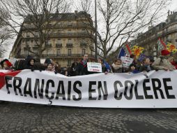 Manifestantes que solicitan la dimisión de Hollande sostienen un cartel donde se lee 'franceses enojados'. AFP /