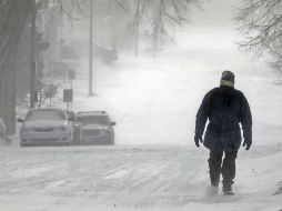 Un hombre camina por una vía nevada en Dakota del Norte. AP /
