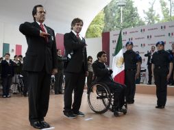 Aquí el momento en el que reciben el lábaro patrio los dos atletas nacionales. MEXSPORT /