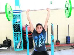 No todo es agua. Carolina Mendoza realiza ejercicios con una barra para entrenar la fuerza explosiva.  /