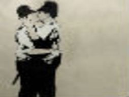 En la icónica obra en blanco y negro, aparecen dos policías británicos besándose. AP /