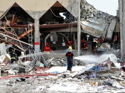 Bomberos trabajan para sofocar el fuego que originó la detonación. AP /