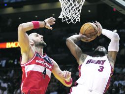 Hasta la cocina. Dwyane Wade penetra a la pintura para disparar a la canasta ante la marcación de Marcin Gortat. AP /