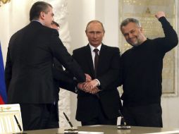 Vladimir Putin (c) estrecha la mano de líderes crimeos. ''Crimea siempre ha sido y seguirá siendo'' parte de Rusia, dice el mandatario. EFE /