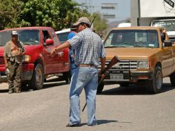 Alrededor de mil 500 personas de autodefensas bloquean la entrada de la base local de la Semar en La Placita, en la costa michoacana. ARCHIVO /