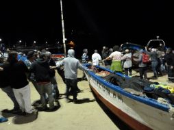 Un grupo de personas saca botes de pesca del agua luego de que se lanzara una alerta de tsunami en costas chilenas. EFE /