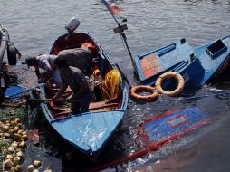 Pescadores a escala pequeña continuan recuperando lo poco que quedó de las embarcaciones dañadas por el oleaje ocasionado por el sismo. EFE /