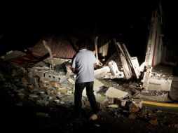 Un camarógrafo camina por los escombros de una casa, destruida por el terremeto y las réplicas en Managua, Nicaragua. ARCHIVO /