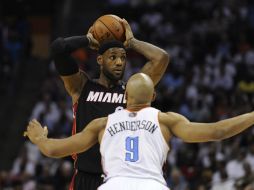 Lebron James (i) busca pasar el balón frente al jugador de Charlotte Bobcats Gerald Henderson (d), durante el partido. EFE /