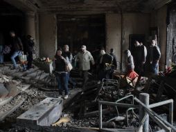Ciudadanos caminan dentro del edificio quemado en Odesa. ARCHIVO /