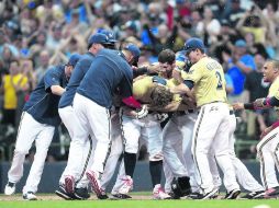 A brindar. Compañeros de Mark Reynolds celebran con el inicialista el triunfo. AFP /